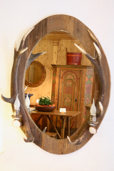 Specchio ovale con cornice in legno antico e luci in corna di cervo 